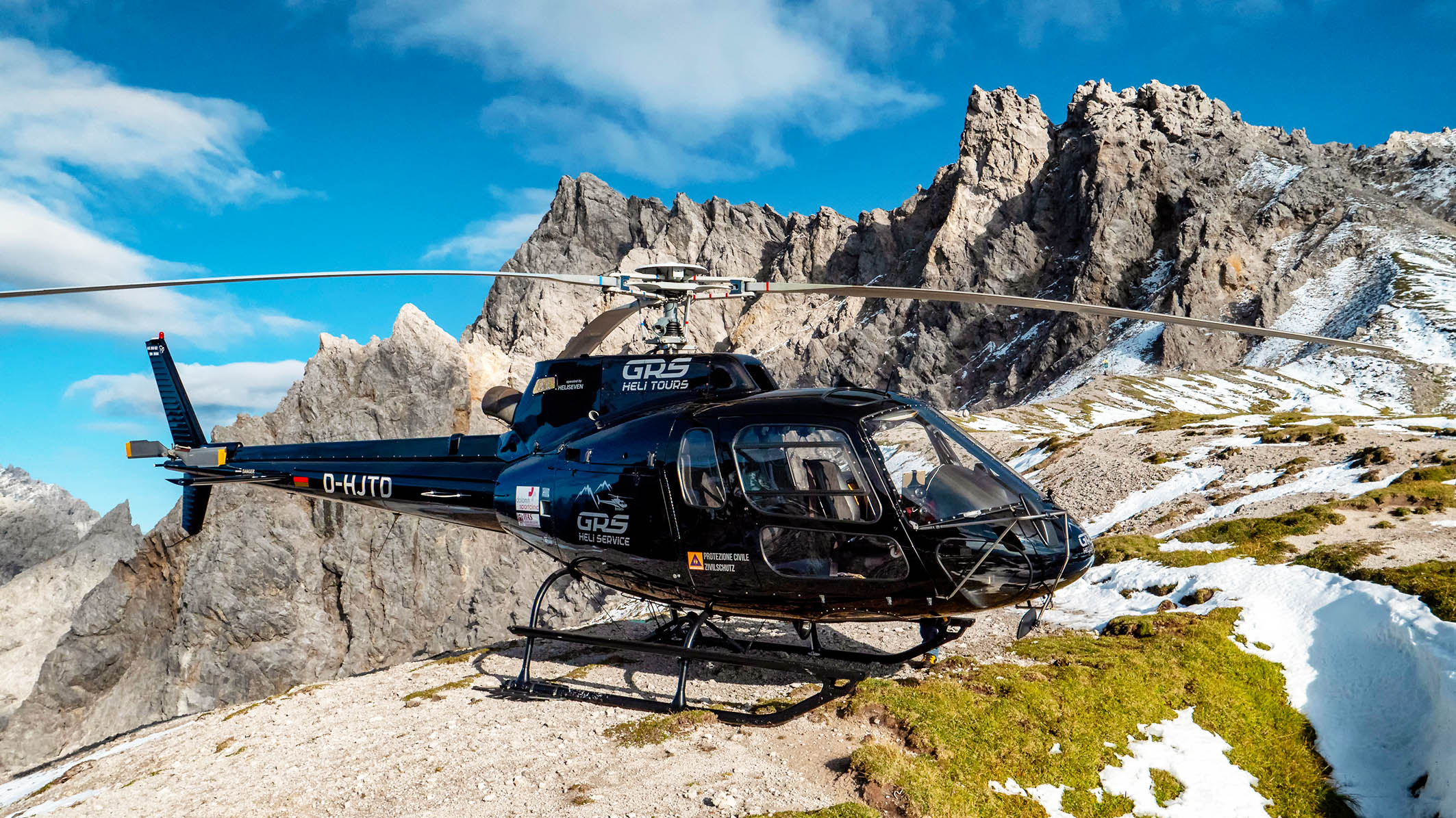 Bild zeigt das einen Helikopter vor einer felsigen Kulisse in den Alpen. (verweist auf: Mit dem Helikopter im Allgäu)