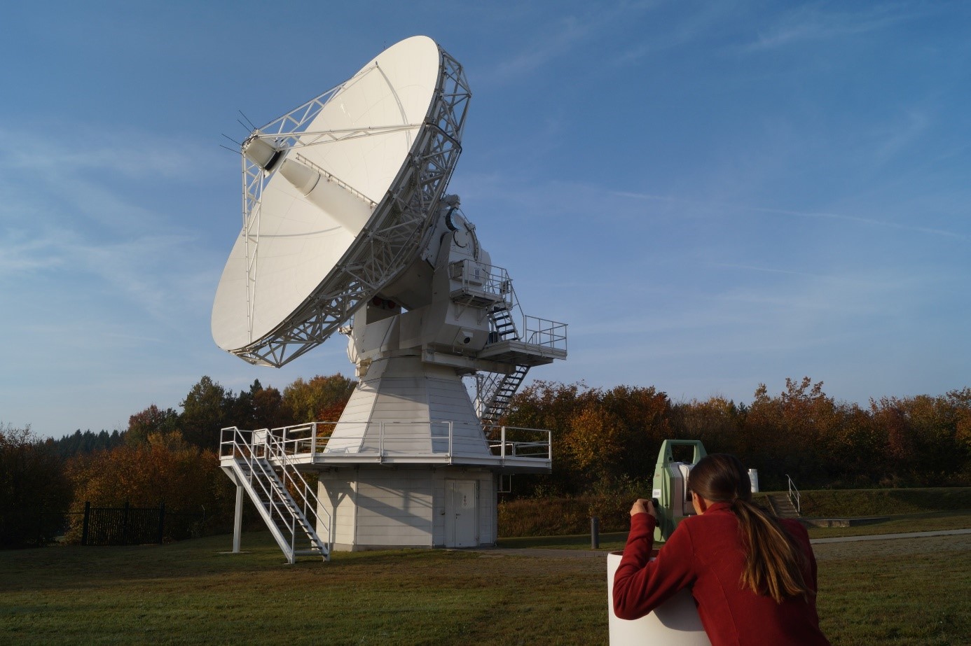 Bild zeigt ein VLBI-Teleskop und einen Tachimeter, an dem eine Messung durchgeführt wird