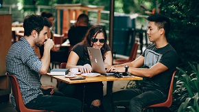 verweist auf: Unsere Benefits Bild zeigt Menschen, die in einem Cafe arbeiten (verweist auf: Unsere Benefits)